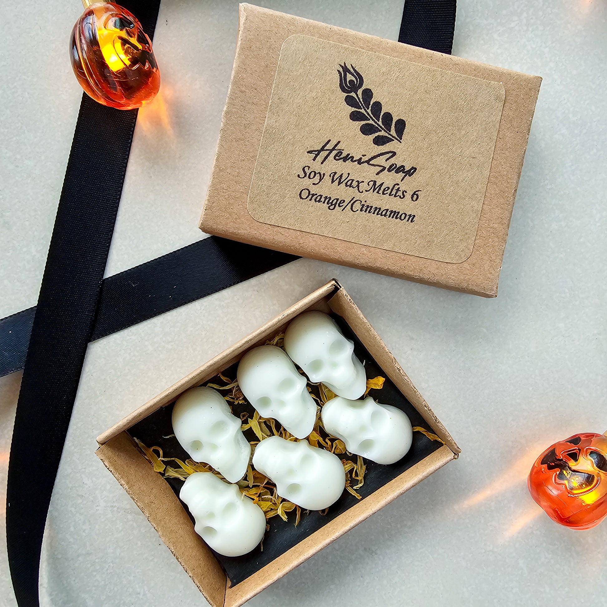 Box of skull-shaped soy wax melts with a branded box on a light background