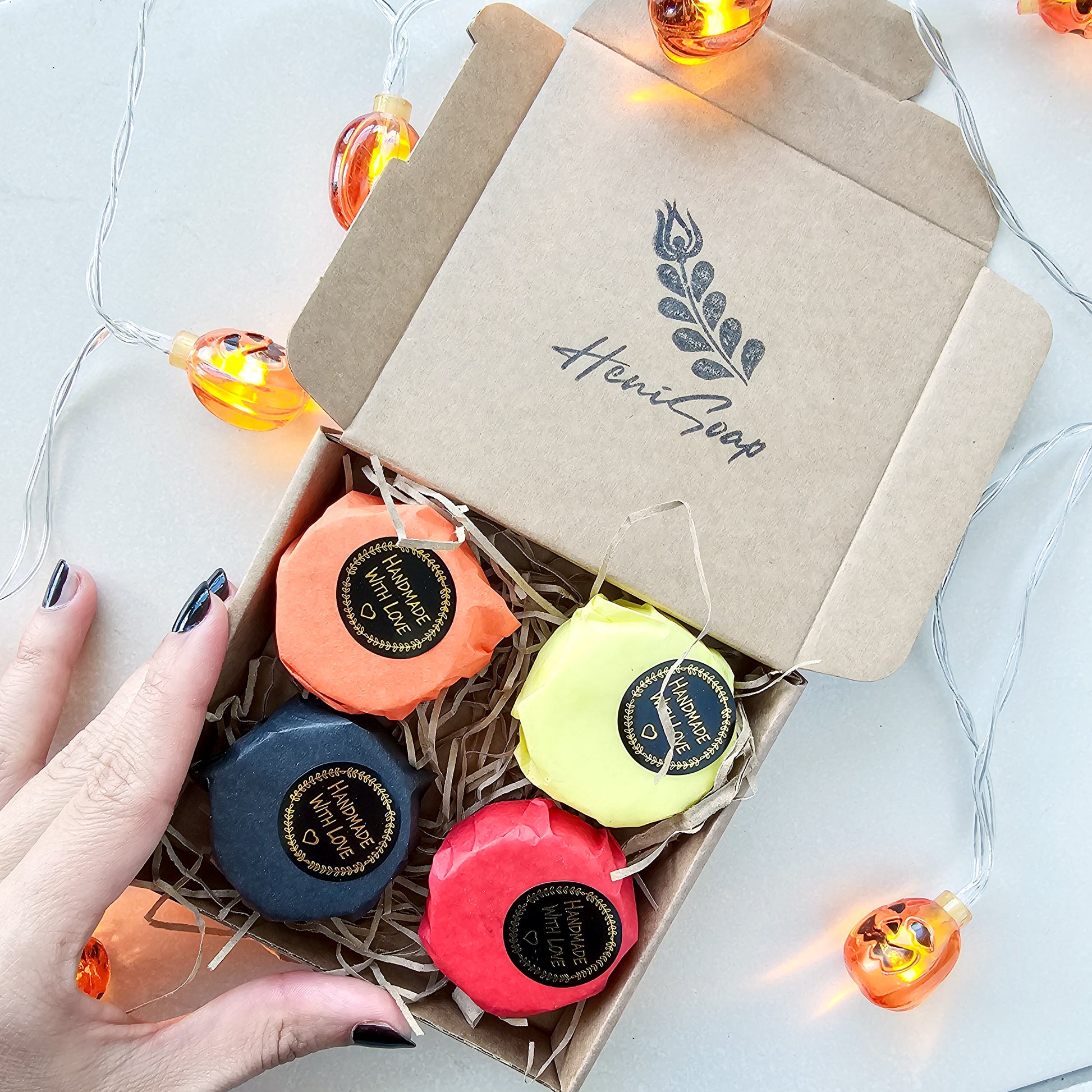 Box of colorful bath bombs with 'Heni Soap' branding on a light background.