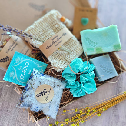Assorted soaps with visible branding in a decorative box on a textured surface.