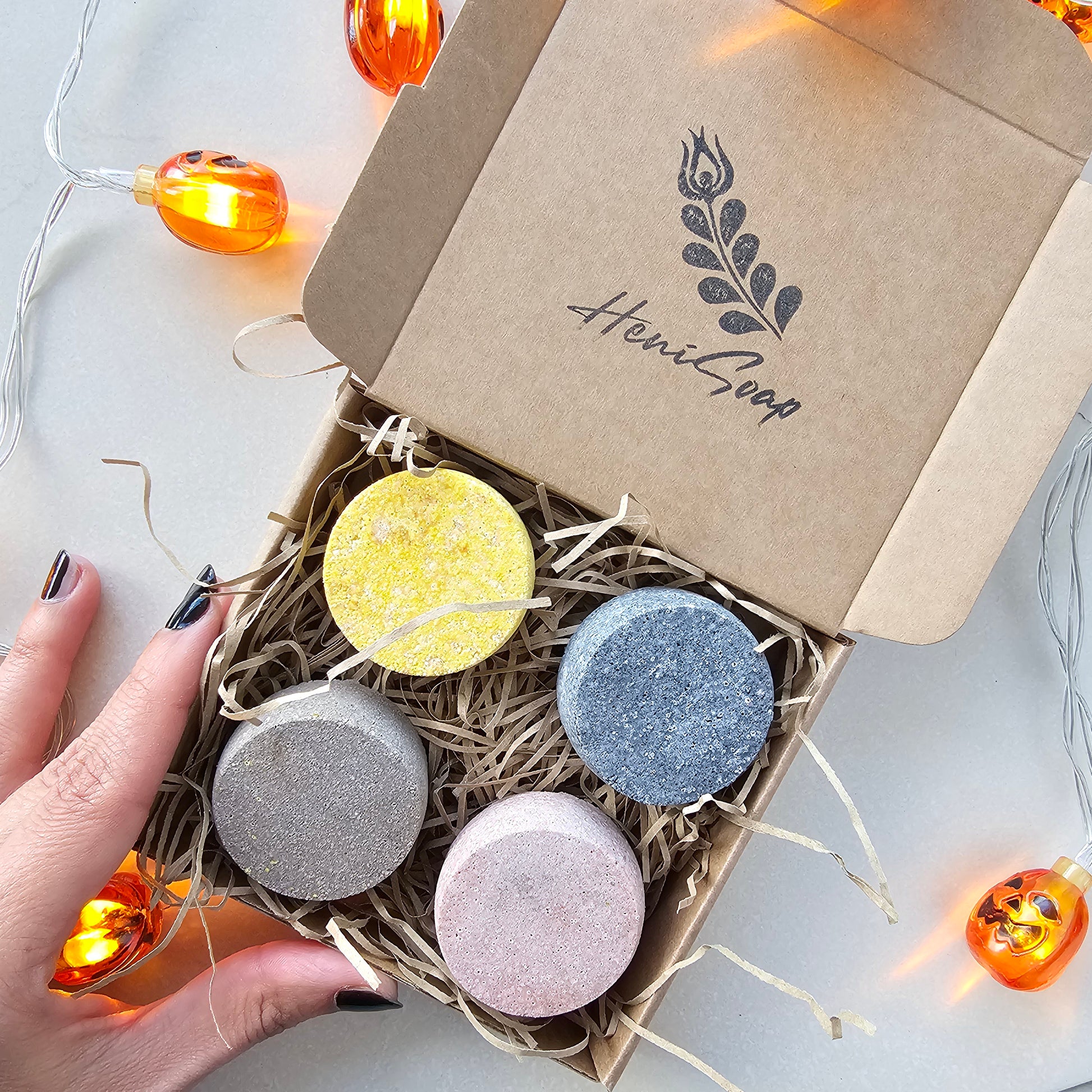Box of colorful shower steamers with 'Heni Goop' branding on a light background.