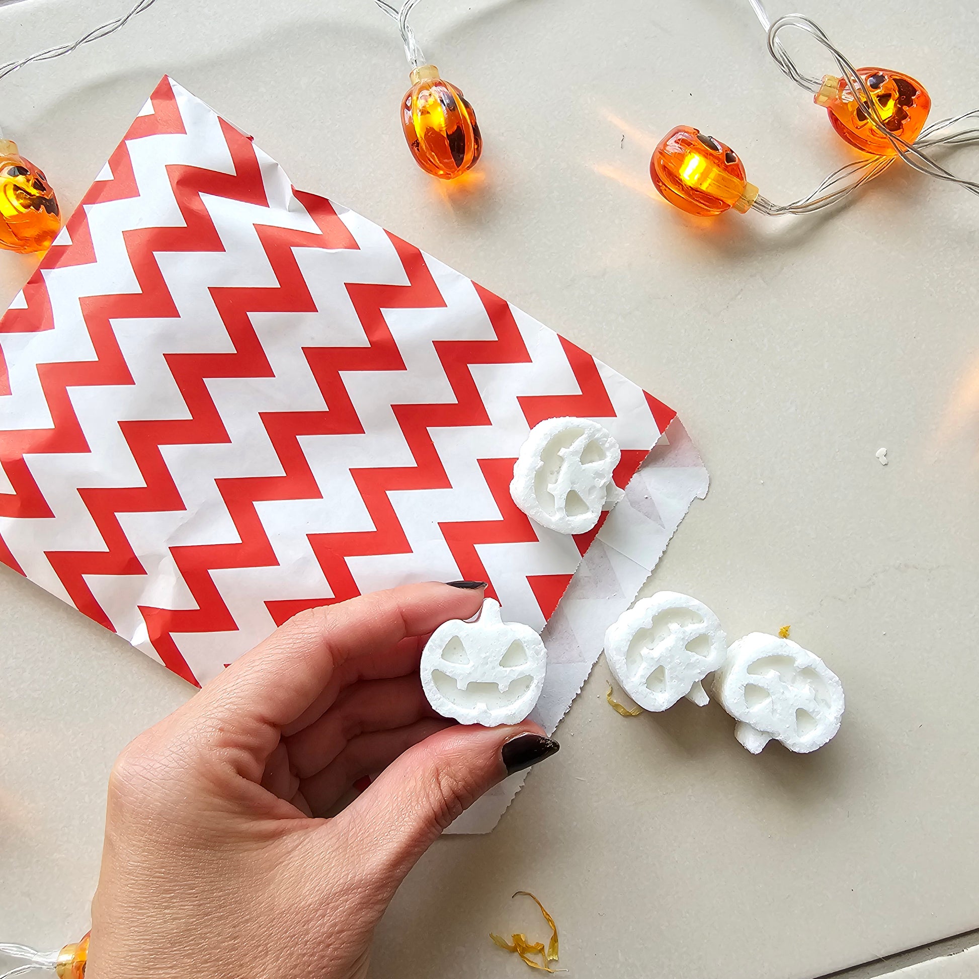  white pumpkin-shaped bath bombs in a red bag