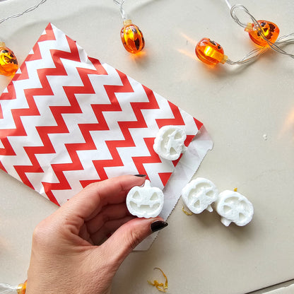  white pumpkin-shaped bath bombs in a red bag