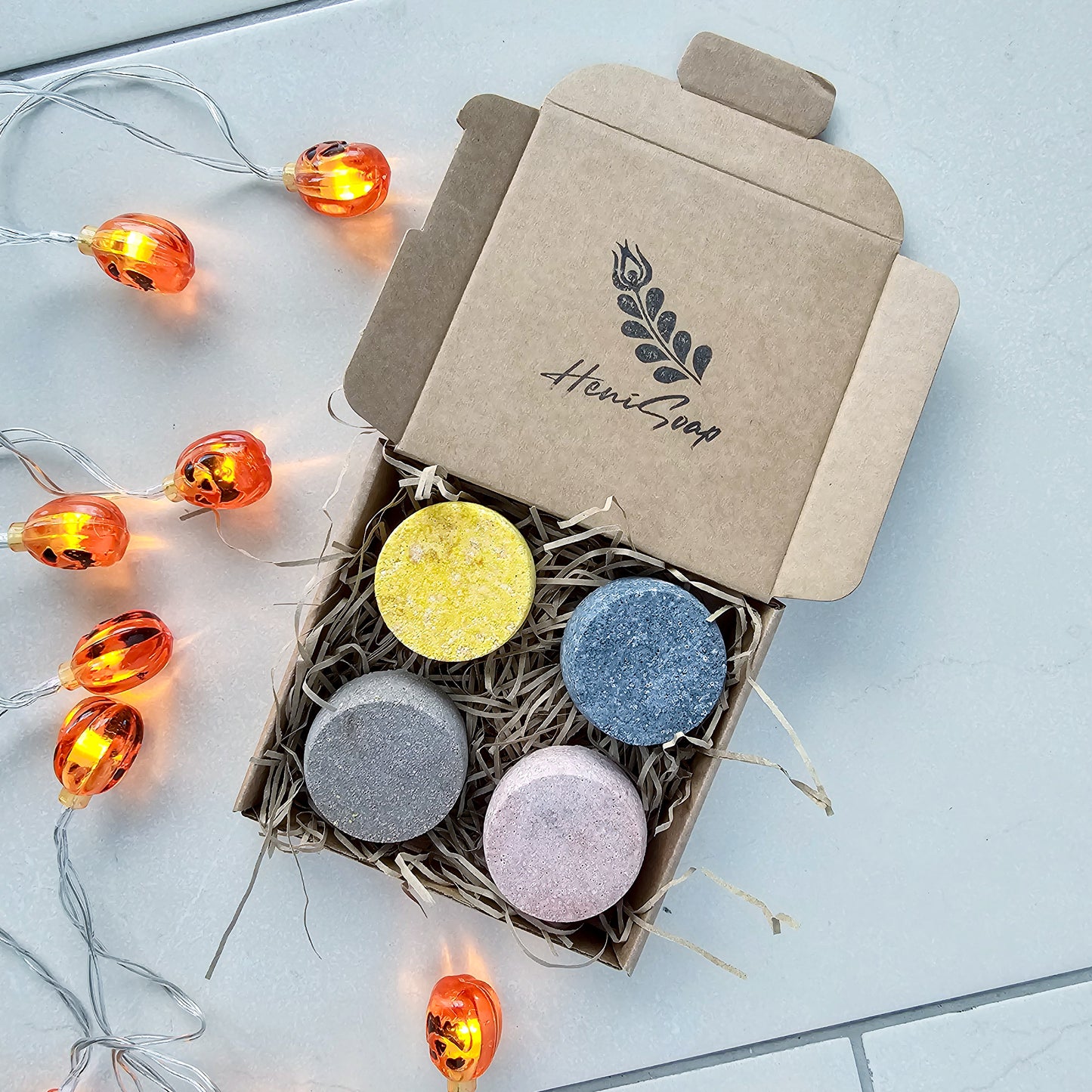 Box of colorful shower steamers with a string of lights 